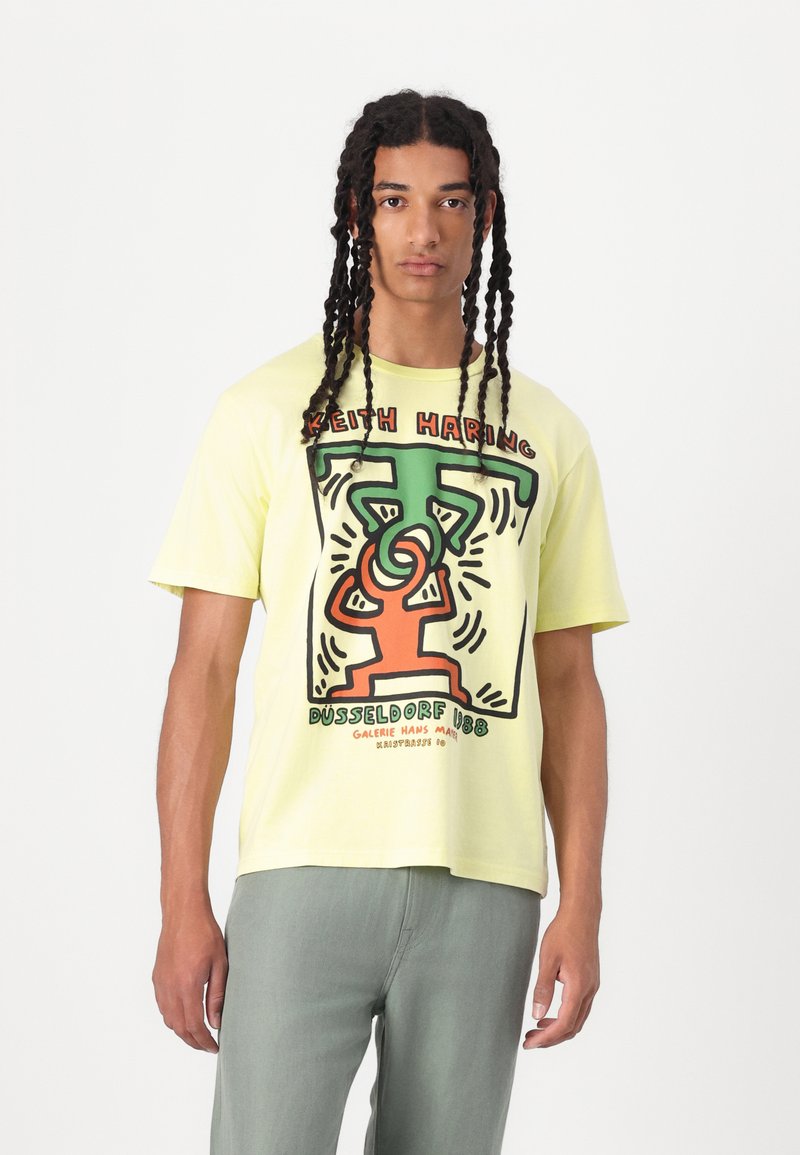 Lichtgele katoen t-shirt met een grafische print in groen, zwart en oranje, met korte mouwen en een relaxed fit.