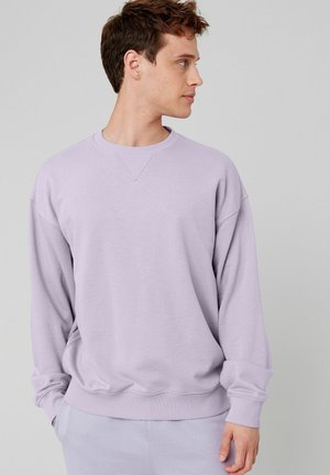 Sweatshirt violet clair avec un col rond, des épaules tombantes et des poignets côtelés. Texture lisse, coupe décontractée avec un design simple.