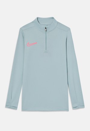 Világoskék, hosszú ujjas pulóver puha anyagból, féllámpás cipzárral és rózsaszín Nike logóval a bal mellen.