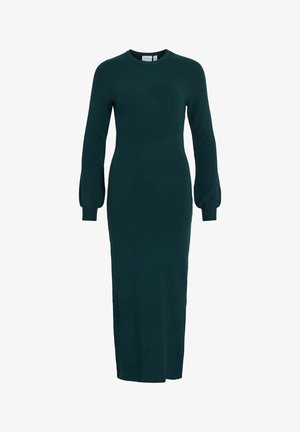 Garšs, pieguļošs zaļš kleitas modelis, izgatavots no ribota adījuma auduma ar apaļu izgriezumu un pūkainām piedurknēm, kas sniedzas līdz pusotrai teļai.