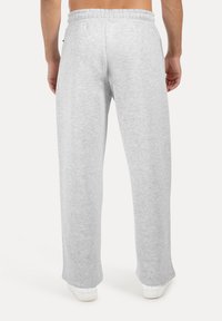 Gray sweatpants made of soft fabric. They feature a relaxed fit and an elastic waistband, with pockets on the sides and a straight leg design.