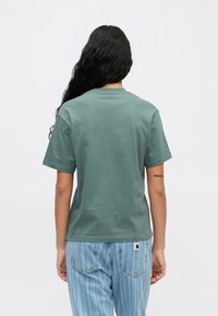 Lühikeste varrukatega tumehall puuvillane T-särk. Rikkalik sobivus, ümmargune kaelus, sile tekstuur. Kombineeritud helesiniste triibuliste teksadega.