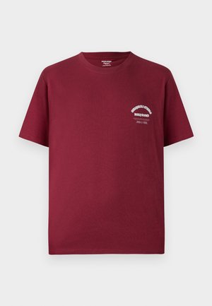 Burgundowa bawełniana koszulka z okrągłym dekoltem, krótkimi rękawami i białym nadrukiem na lewej piersi. Gładka tekstura i luźny krój.