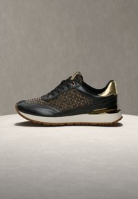 Μαύρο αθλητικό παπούτσι με χρυσές λεπτομέρειες, υφασμένη επάνω επιφάνεια με διακοσμητικά τρουκ, και γυαλιστερό χρυσό τακούνι. Λευκή μεσαία σόλα και λαστιχένια εξωτερική σόλα.