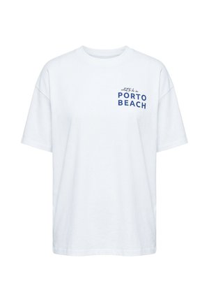 Hvid T-shirt med korte ærmer og blå tekst på brystet, der lyder "hvad man skal gøre i PORTO BEACH" i blandede skrifttyper.