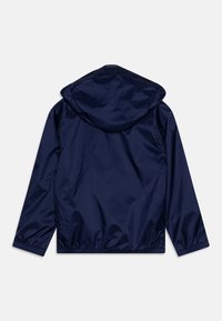 Veste légère bleu marine avec capuche, fabriquée en matière lisse et brillante ; poignets et ourlet élastiques ; design simple sans quincaillerie visible.