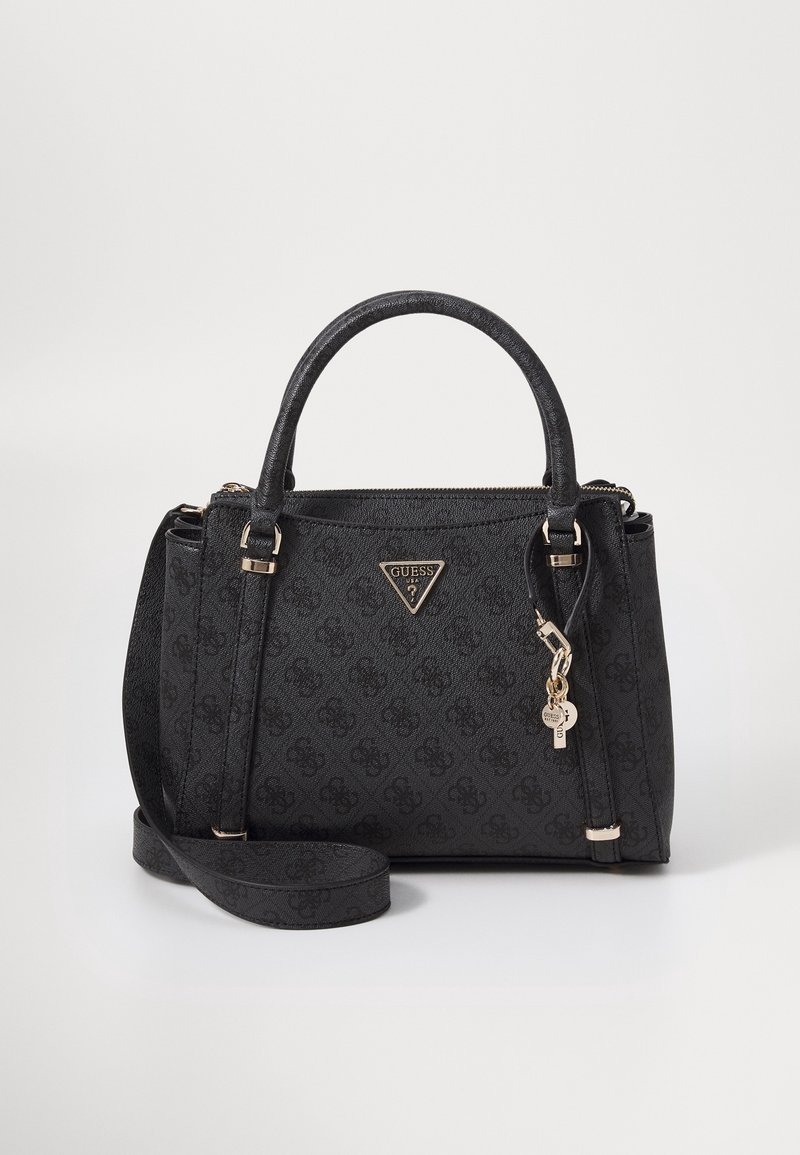 Sac à main Guess noir avec deux poignées, bandoulière amovible, plaque logo dorée et porte-clés sur fond blanc uni.