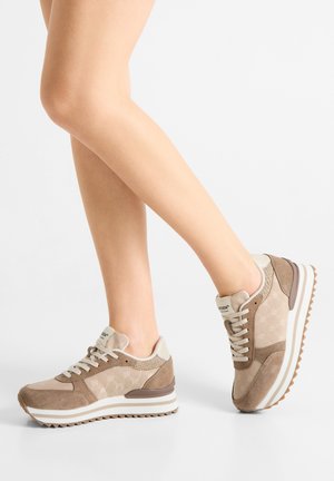 Beige sportschoenen van suède en mesh, met een dikke witte zool, gestructureerde accenten en een vetersluiting.
