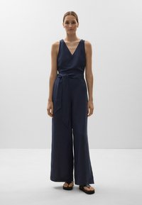 Navyfarbener Leinen-Overall mit V-Ausschnitt, weiten Beinen und gebundenem Taillenbereich. Verfügt über eine glatte Textur und ein minimales Design mit tailliertem Oberteil.
