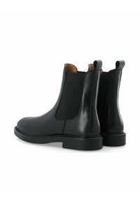 Stivali Chelsea in pelle nera con pannelli elastici laterali e linguette per l'estrazione, caratterizzati da una texture liscia e punta arrotondata. Suola in gomma.