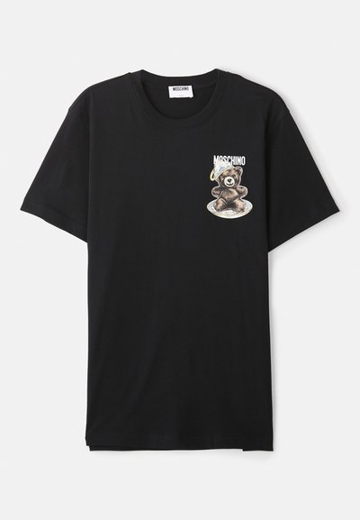 T-shirt preta feita de algodão com decote redondo. Apresenta um gráfico de um urso a usar um capacete espacial na área do lado esquerdo do peito.