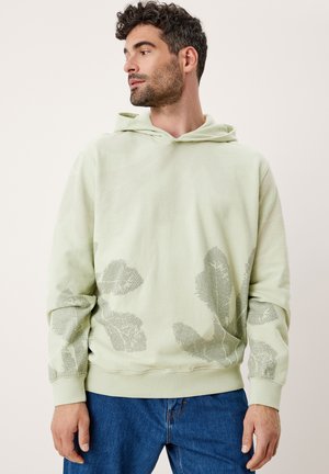 Sudadera verde claro con un patrón de hojas texturizadas en un tono más oscuro. Presenta un bolsillo tipo canguro en la parte delantera y puños acanalados, hecha de material suave.