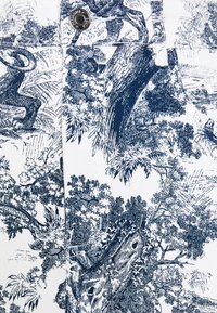 Vitt tyg med ett detaljerat blått toilemönster med träd och lövverk. Inkluderar en metallknapp och design med framficka.