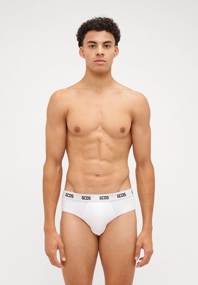 Weiße Baumwollslips mit einem schwarzen Bündchen, auf dem das Logo "GCDS" abgebildet ist. Enganliegendes Design mit glatter Textur, das die Körperform betont.