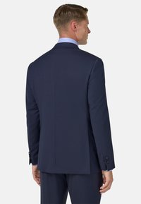 Temno modra po meri krojena suknja, z enim razporkom, z odrezanimi ovratniki, z dvema gumboma na rokavih in teksturiranim zaključkom.