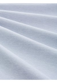 Ljusblått tyg med en mjuk, slät textur, som har en fin, jämn väv och försiktiga veck, vilket skapar ett flödande utseende.