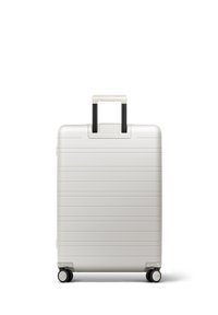 Weißer Hartschalenkoffer mit Rillen, schwarzem teleskopierbarem Griff und vier Rädern. Glatte Textur und minimalistisches Design.