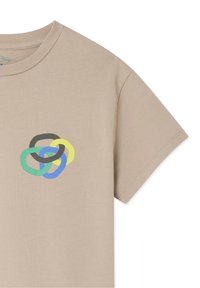 T-shirt beige à manches courtes avec un col rond et un motif central représentant quatre anneaux entrelacés en noir, jaune, bleu et vert.