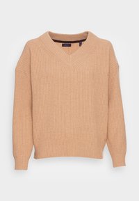 Beżowy sweter dzianinowy w prążki z dekoltem w kształcie V i długimi rękawami, charakteryzujący się luźnym krojem i mankietami.