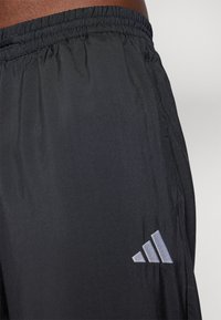 Mustad must sportlikud lühikesed püksid elastse vööga. Omavad peent sädelust, võrgu tekstuuri ja väikest halli Adidas logo alumisel külgedel.