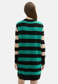 Sukienka swetrowa w paski z wyraźnymi poziomymi pasami w kolorach zielonym, czarnym i beżowym. Wykonana z miękkiego materiału, z długimi rękawami i bocznymi rozcięciami.