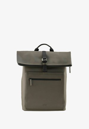 Mochila gris mate con solapa superior sujeta por una correa negra y un cinturón, bolsillo frontal con cremallera y una pequeña asa en la parte superior.