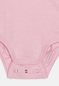 Lyserød bomuldsbodysuit med en glat tekstur, der har en rund halsudskæring og trykknaplukninger i bunden. Enkel design uden mønstre.