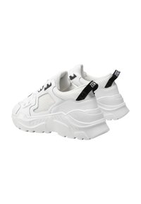 Des chaussures de sport blanches avec une semelle épaisse, une tige en maille, un col rembourré et des accents noirs au niveau du talon et de la languette pour un soutien et une respirabilité.