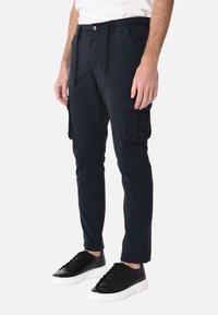 Pantaloni cargo blu navy con elastico in vita, lacci regolabili, due tasche laterali e una grande tasca cargo sulla gamba destra.