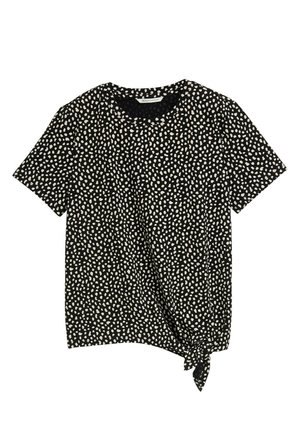 Schwarzes Kurzarmshirt mit einem weiß gepunkteten Muster. Es hat ein geknotetes Detail an der unteren linken Seite für zusätzlichen Designakzent.