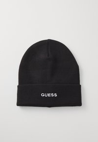 Bonnet en tricot noir avec un revers replié, portant l'inscription "GUESS" brodée en blanc à l'avant. Texture lisse, forme de sommet arrondie.
