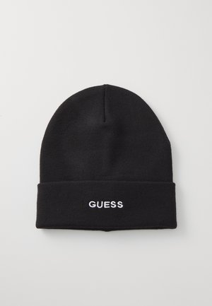 Bonnet en tricot noir avec un revers replié, portant l'inscription "GUESS" brodée en blanc à l'avant. Texture lisse, forme de sommet arrondie.
