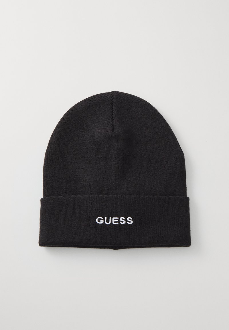 Bonnet en tricot noir avec un revers replié, portant l'inscription "GUESS" brodée en blanc à l'avant. Texture lisse, forme de sommet arrondie.