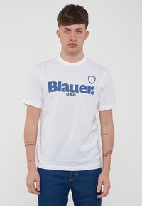 T-shirt bianca in cotone con un grande logo blu "Blauer." e il testo "USA" più piccolo. Collo rotondo e maniche corte, design minimalista.