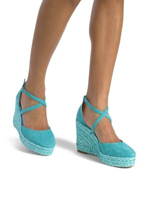 Scarpe con zeppa in suede aqua con suola intermedia in juta intrecciata e cinturini incrociati alla caviglia. La punta arrotondata e la superficie texturizzata migliorano la presa.