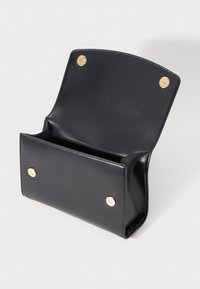 Black leather clutch purse open with gold snap button closures, shown against plain white background.