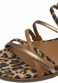 Sandale s leopard uzorkom s smešnim trakama i metalnim naglascima. Mekana tekstura i tanka, ukrižena konstrukcija s mekanim đonom.