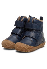 Botas de tobillo de cuero azul marino con dos correas de Velcro, forro de piel suave y suela de goma texturizada para tracción.