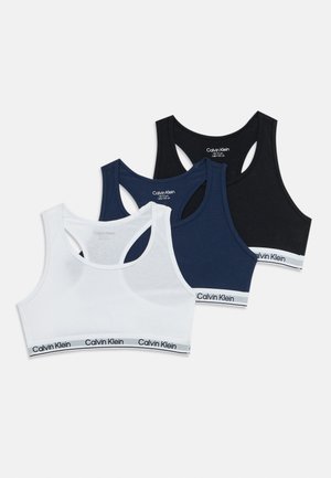 Tri vrste sportskih grudnjaka Calvin Klein u bijeloj, mornarskoj i crnoj boji, ravno položene s dizajnom s posječene leđa i elastičnim trakama s logom.