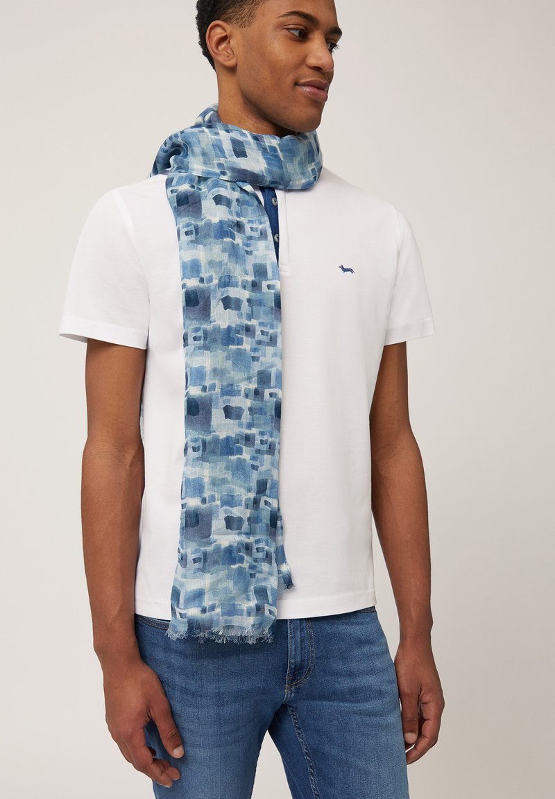 Blå mönstrad scarf i lätt tyg, med ett mönster av abstrakta former i olika nyanser av blått och fransade kanter.