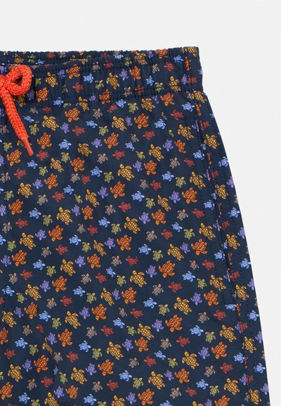 Granatowe szorty z wzorem żółwia w kolorach pomarańczowym, niebieskim i zielonym. Posiadają elastyczny pas z pomarańczowym sznurkiem oraz gładką fakturę.