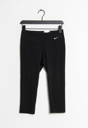 Black athletic leggings made of stretchy material with a wide waistband. Features a small white Nike logo on the front.