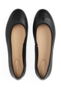 Sorte skinn balletflats har en avrundet tå, elastisk åpning og en subtil preget logo på tåen. Myk beige såle detaljer.