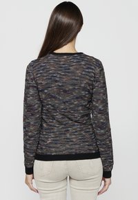 Pull en maille dans des teintes sombres avec des éclats multicolores. Doté de manches longues, de poignets côtelés noirs et d'un col rond.