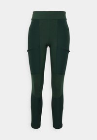 Vihreät legginssit, joissa on korkea vyötärö, useita vetoketjullisia taskuja, kontrastiväriset paneelit ja sileä, joustava kangas.