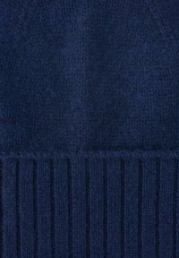 Navy blue knitted beanie with a textured surface. Features a ribbed cuff at the bottom, made from soft, fuzzy yarn.