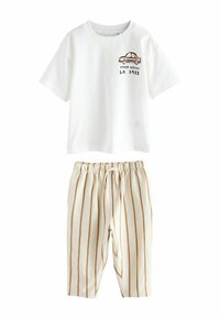 Valkoinen t-paita, jossa on auton graafinen kuva ja teksti, yhdistettynä raidallisiin vaaleanbeigeisiin ja ruskeisiin joustovyötäröisiin housuihin. Pehmeää puuvillamateriaalia, rento muotoilu.