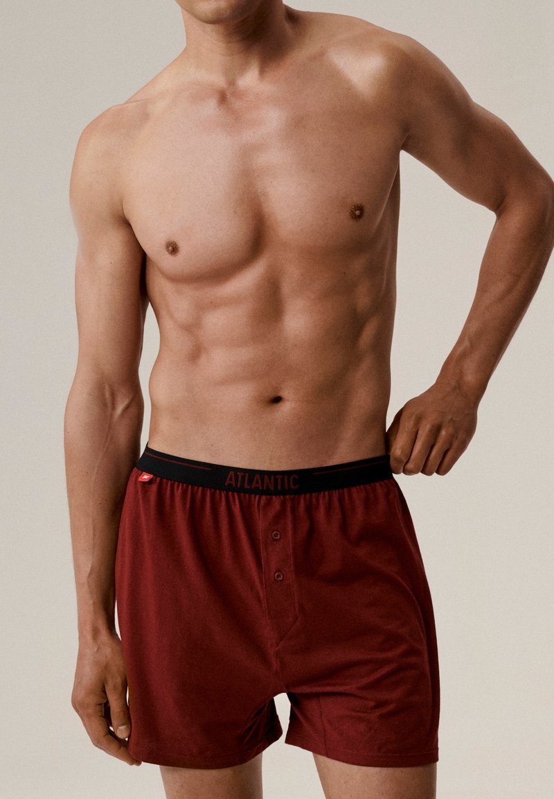 Czerwone bawełniane bokserki z czarnym elastycznym pasem z logo "ATLANTIC", z przodu z zapięciem na guzik oraz gładką fakturą.