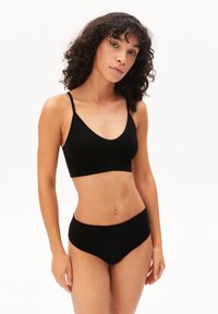 Zwarte geribbelde bralette met dunne bandjes en een brede band, gecombineerd met bijpassend hoge tailleondergoed, beiden met een gladde textuur.