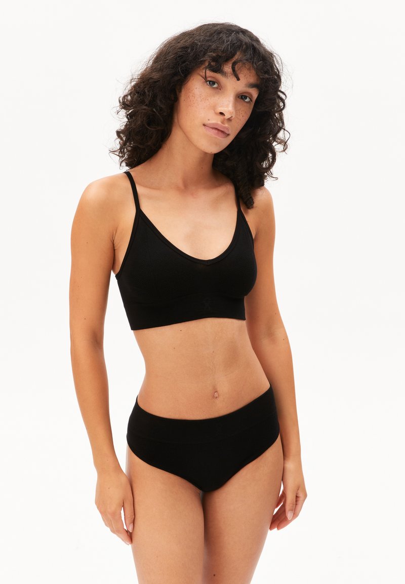 Zwarte geribbelde bralette met dunne bandjes en een brede band, gecombineerd met bijpassend hoge tailleondergoed, beiden met een gladde textuur.